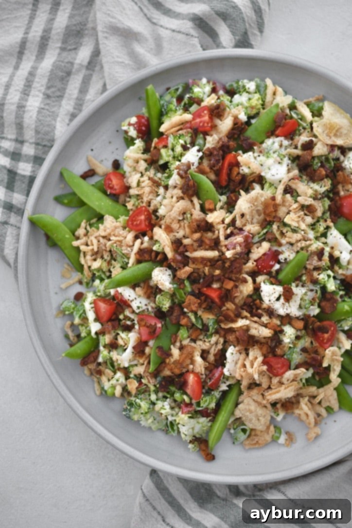 Crisp Snap Pea Salad 7 The finished Snap Pea Salad, artfully arranged on a platter and garnished with additional crispy onions and bacon bits, ready for serving.