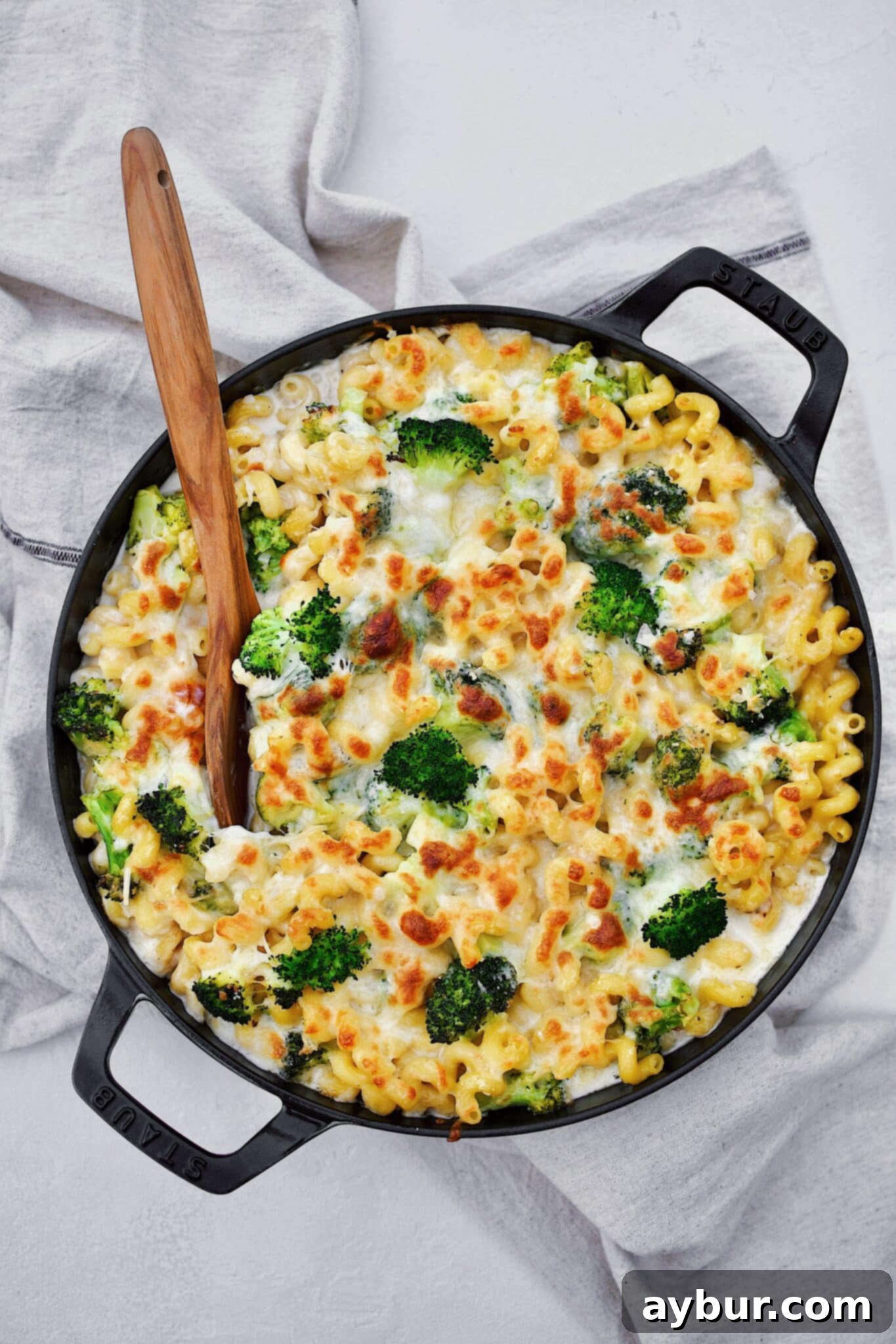 Alfredo Broccoli Pasta in the baking dish after baking to golden brown, spooning some out.