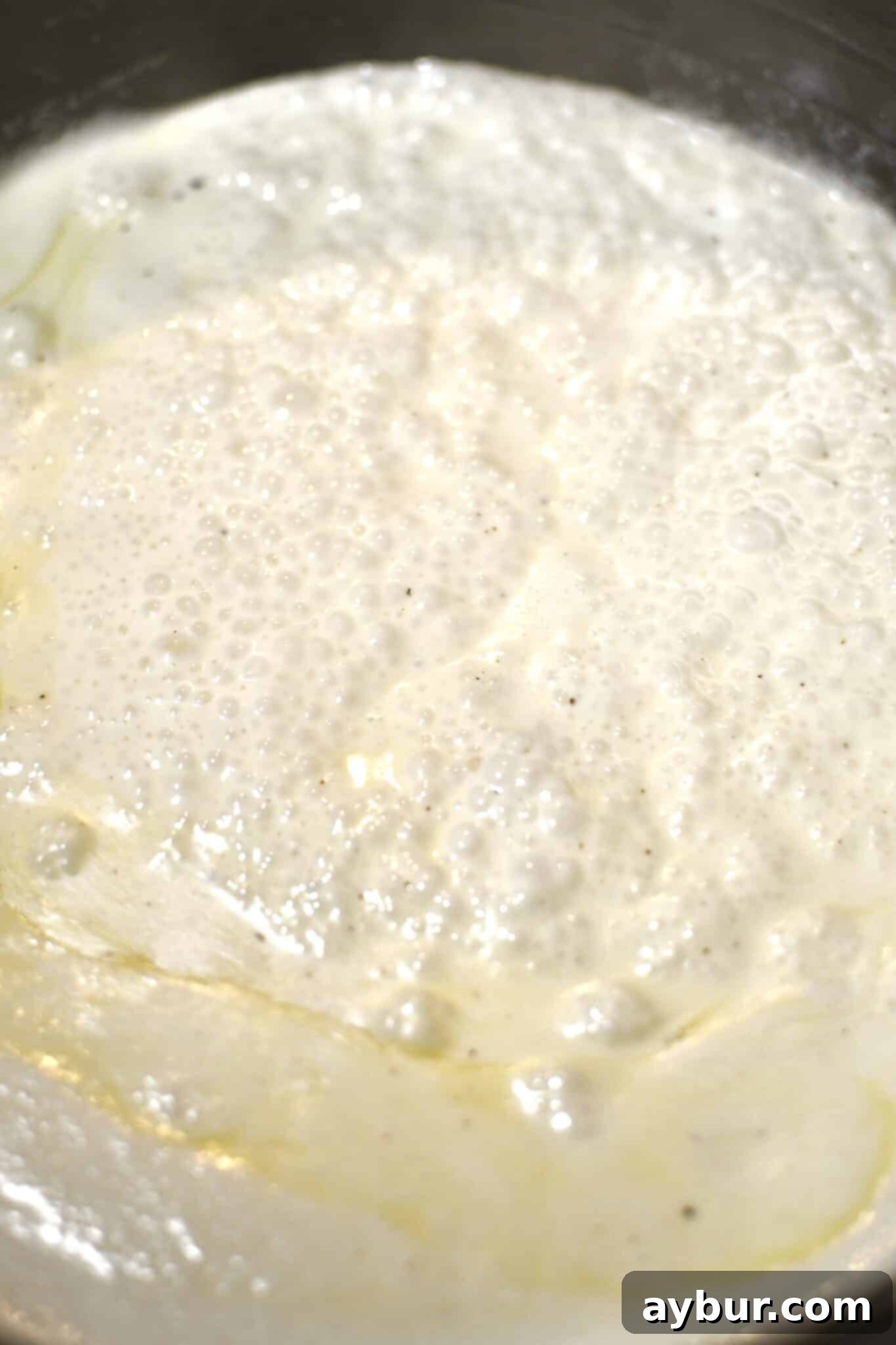 Simmering cream in a large pot.