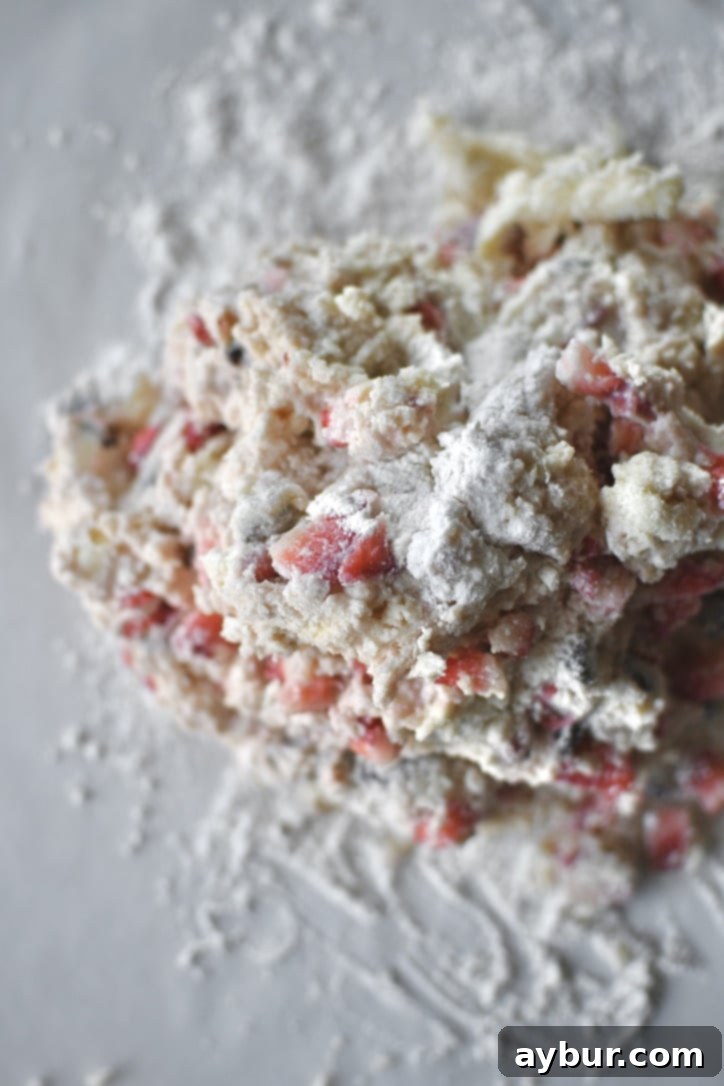 Scone dough gently turned out onto a well-floured surface, ready for folding and shaping.