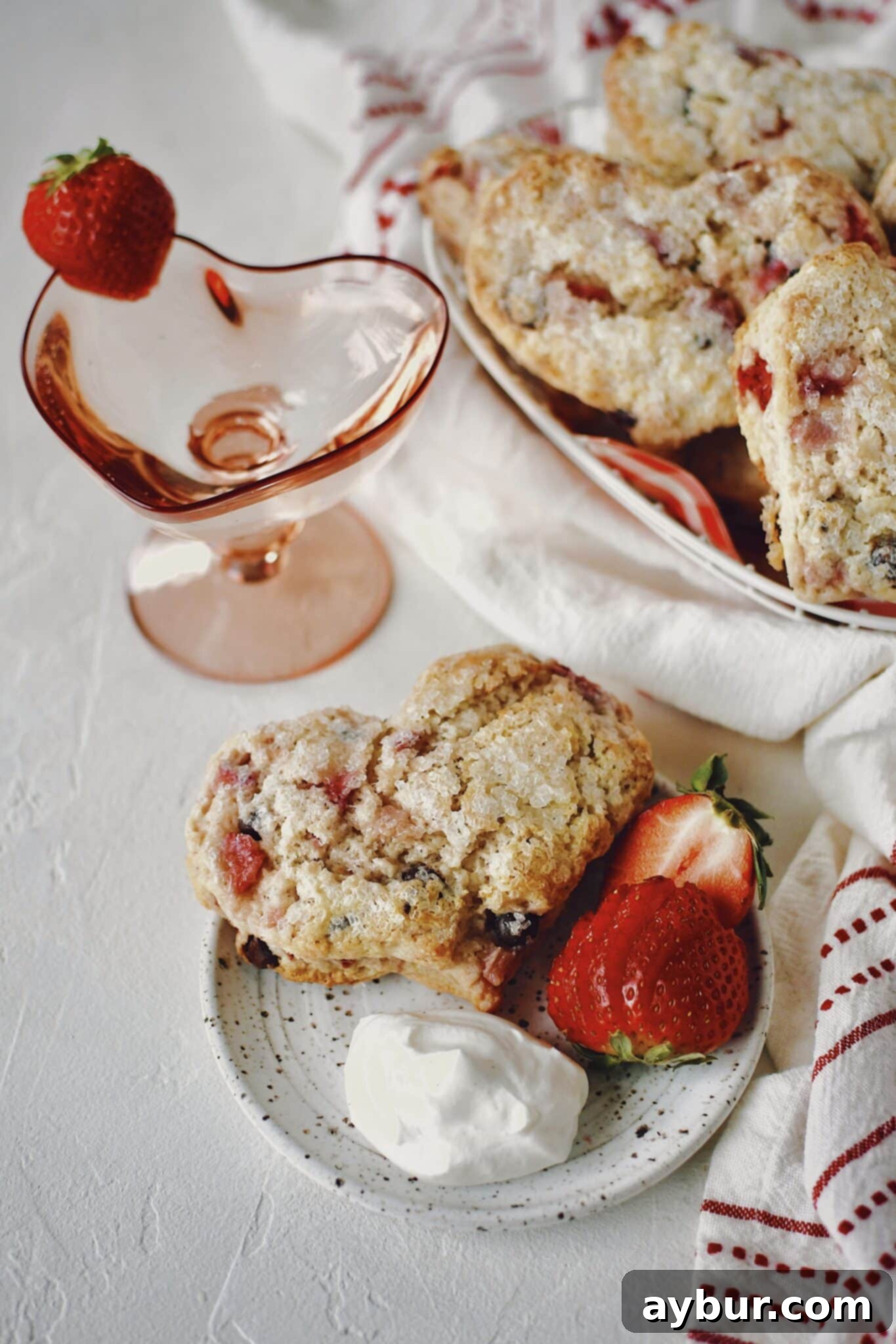 A charming plate of heart-shaped Strawberry Scones, dusted with sugar and ready for a festive occasion.