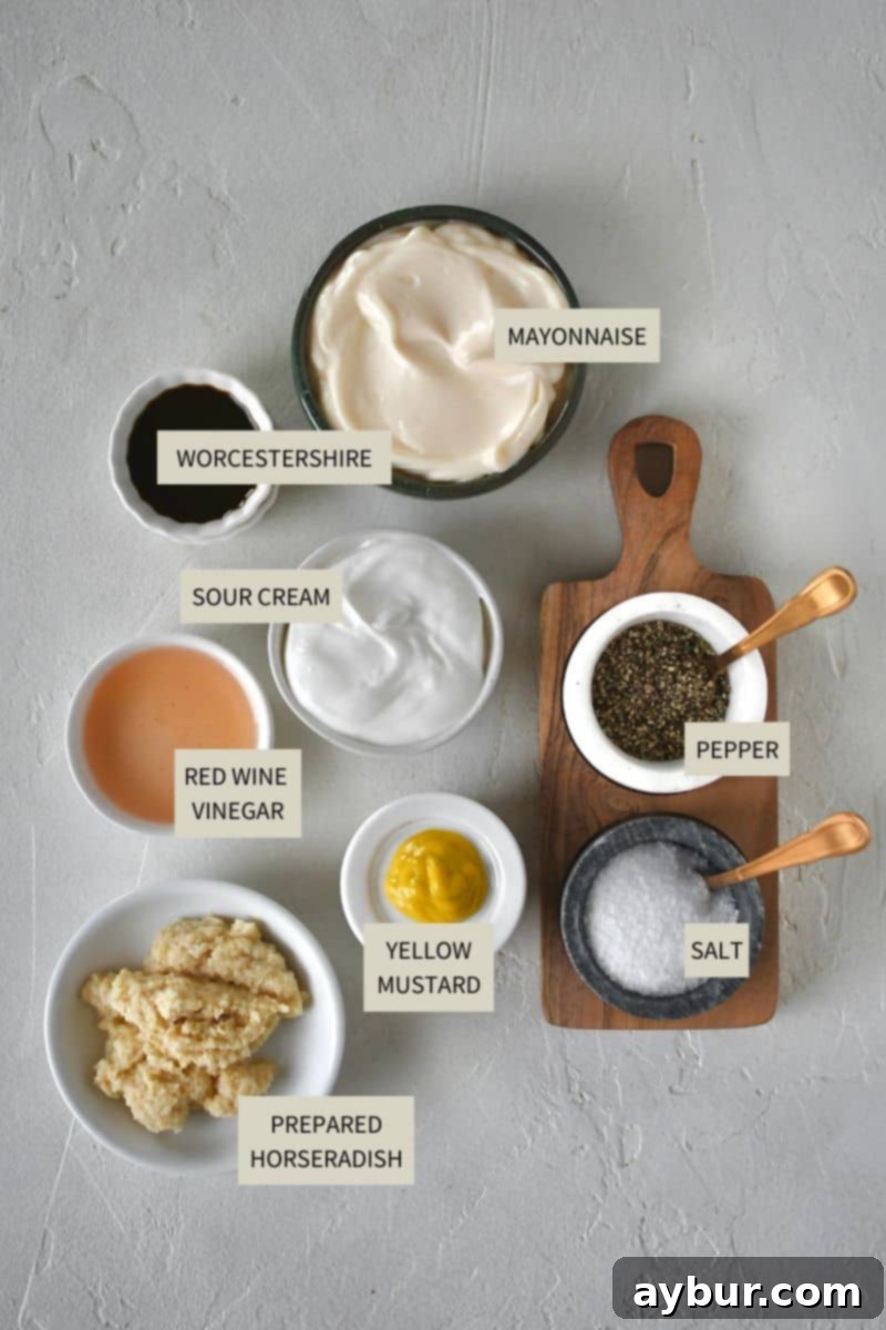 Various ingredients for horseradish cream sauce, including mayonnaise, sour cream, prepared horseradish, mustard, red wine vinegar, Worcestershire sauce, salt, and pepper, arranged on a countertop.