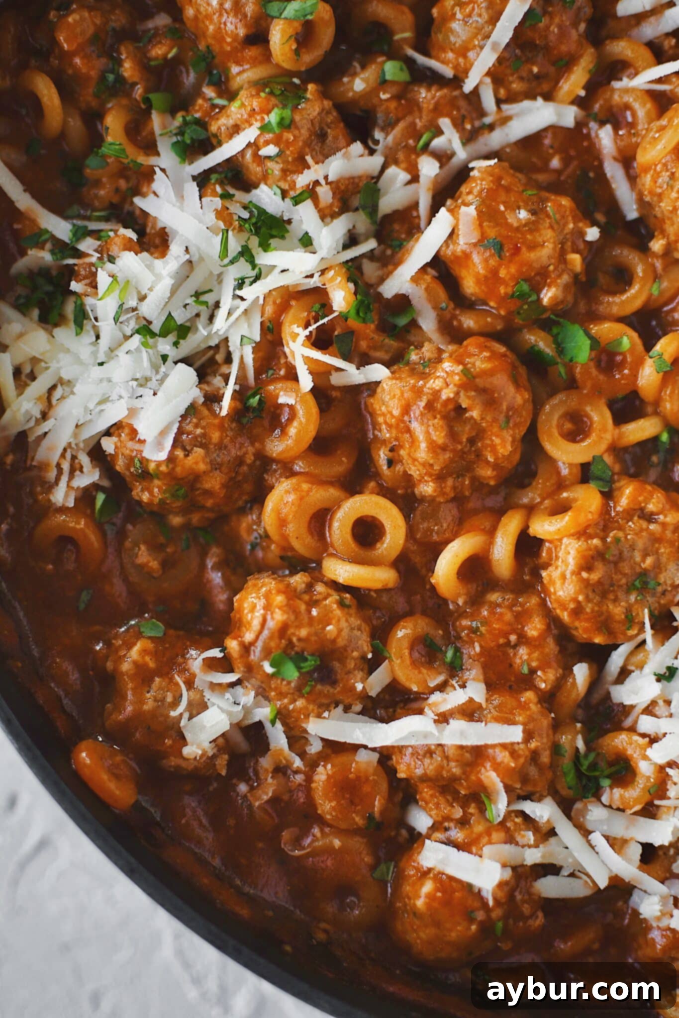 Homemade Spaghettios with meatballs in the pan, garnished and ready to be served from the pan.
