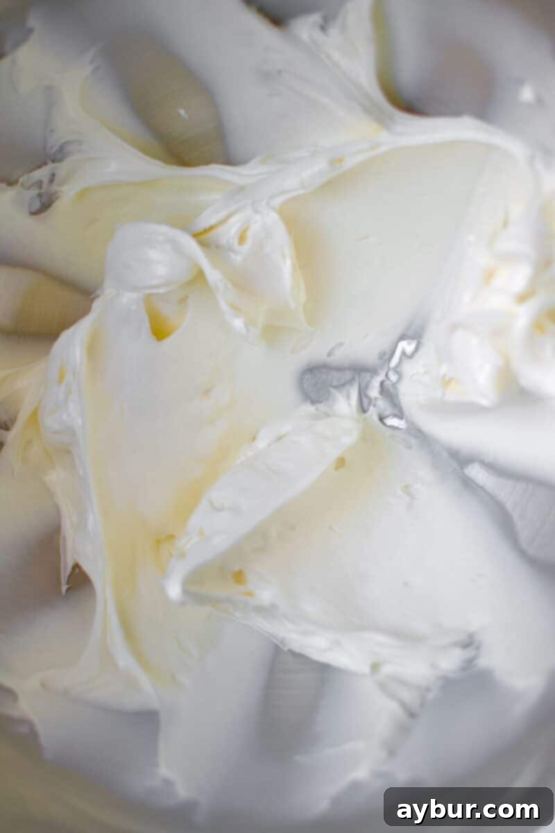 Peanut Butter Paradise Pie 4 Cream cheese and powdered sugar being beaten together until light and fluffy in the bowl of a stand mixer.