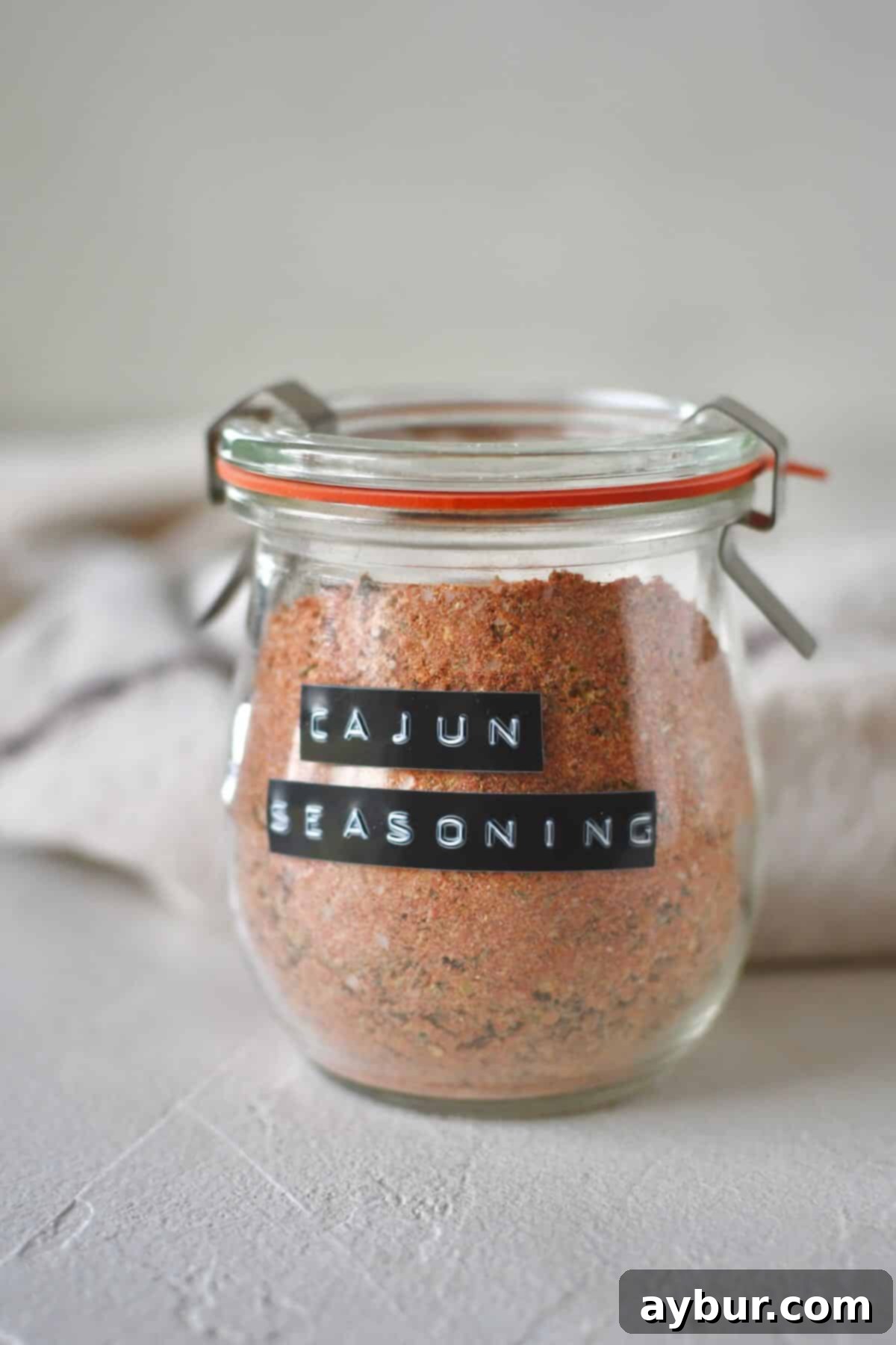 Blended Cajun Seasoning in a jar, with some spilled around the rim.