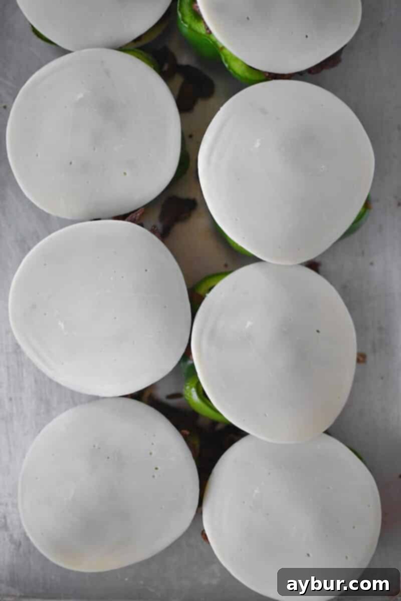 Stuffed Peppers with Philly Cheesesteak 11 A second slice of provolone cheese carefully placed on top of the stuffed peppers, covering the beef and vegetable filling.