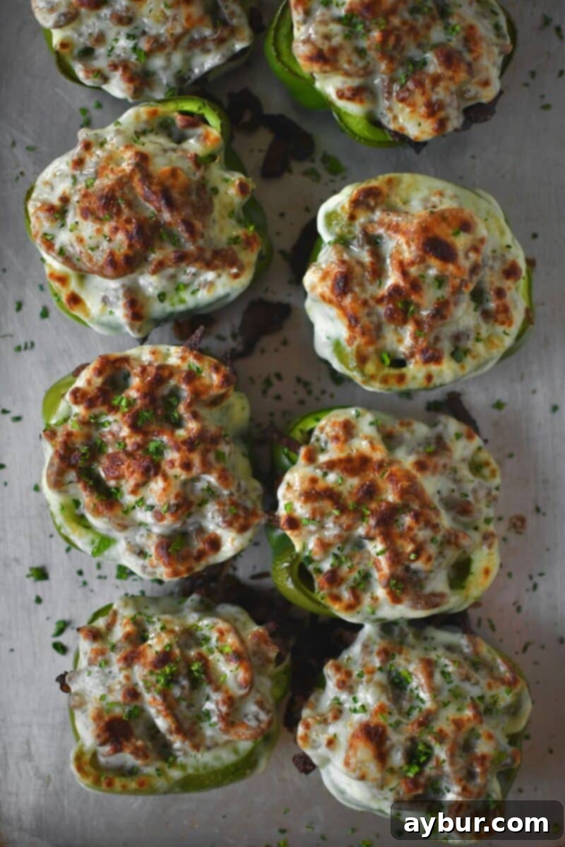 The finished stuffed peppers, with melted and perfectly browned provolone cheese creating an inviting, bubbling crust after broiling.