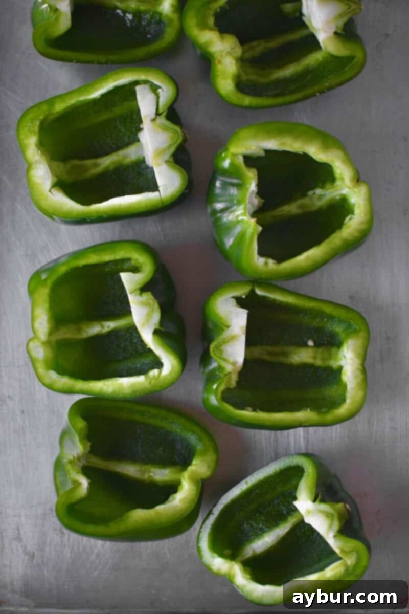 Halved bell peppers that have been carefully cleaned, with all seeds and ribs removed, ready for roasting.
