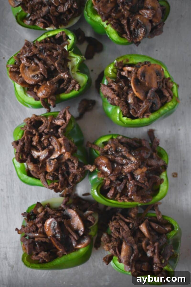 Generous portions of the savory beef, onion, and mushroom filling meticulously stuffed into each bell pepper half.