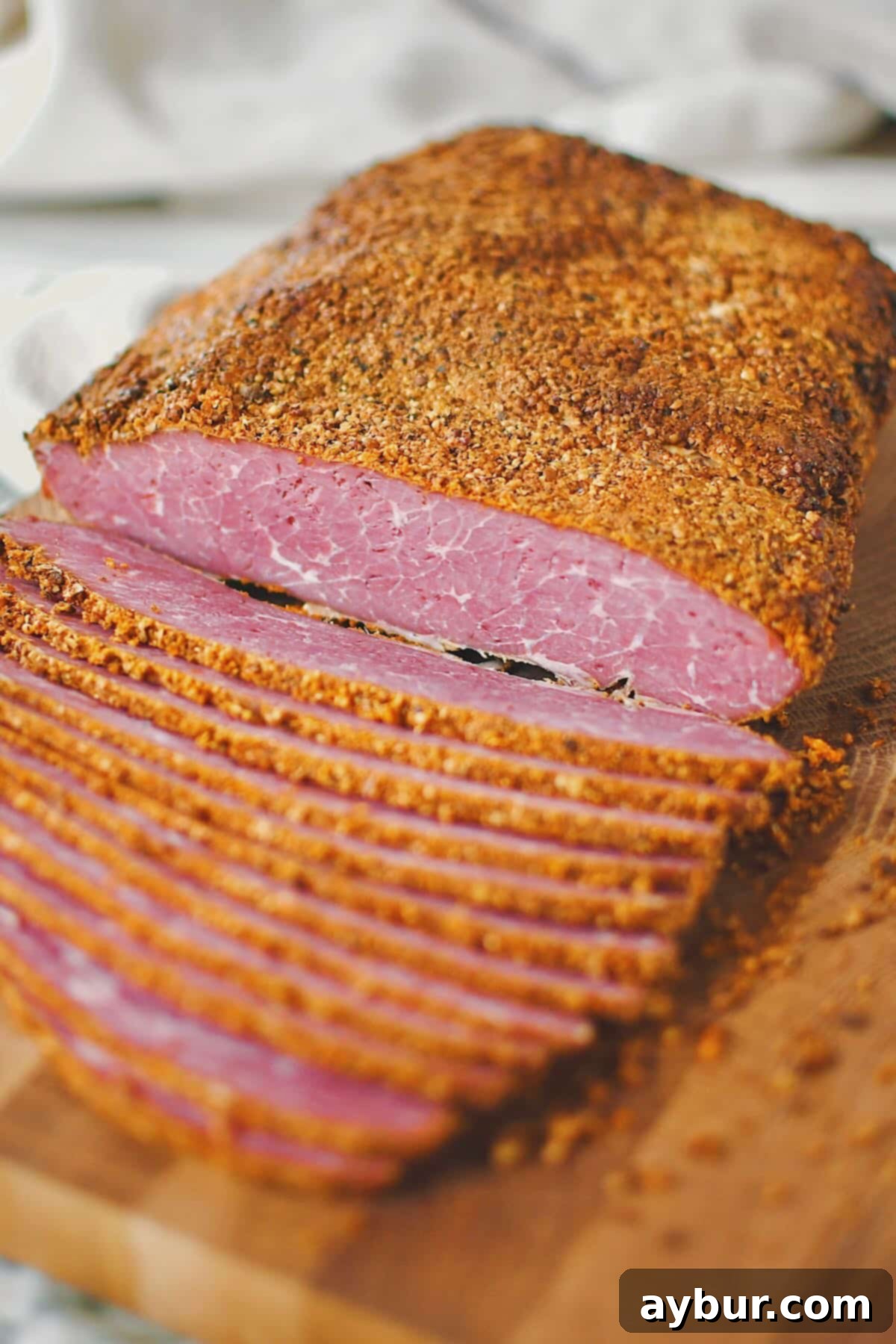 Thinly sliced, tender homemade pastrami stacked and ready for serving.