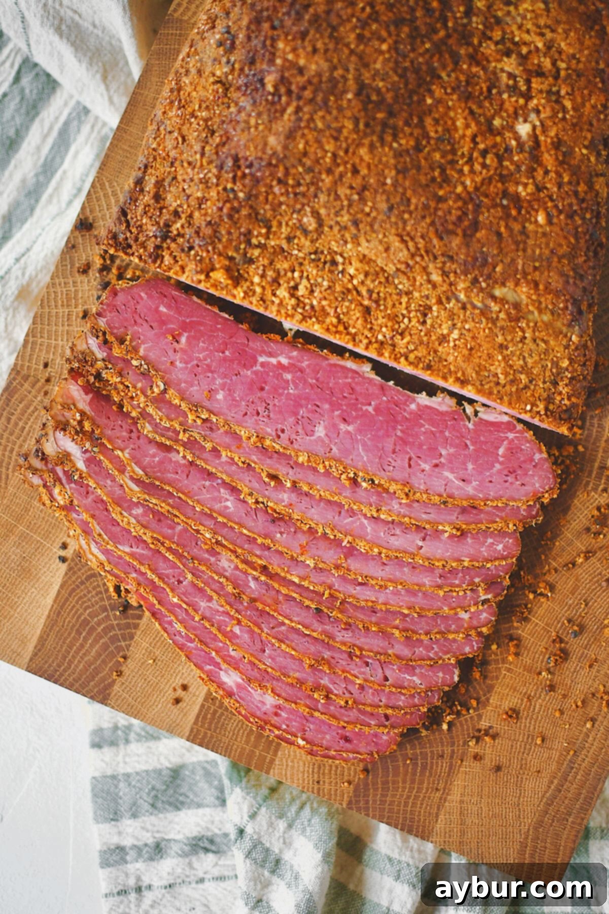 A large slab of homemade pastrami, perfectly cooked and rested, ready to be sliced and served.