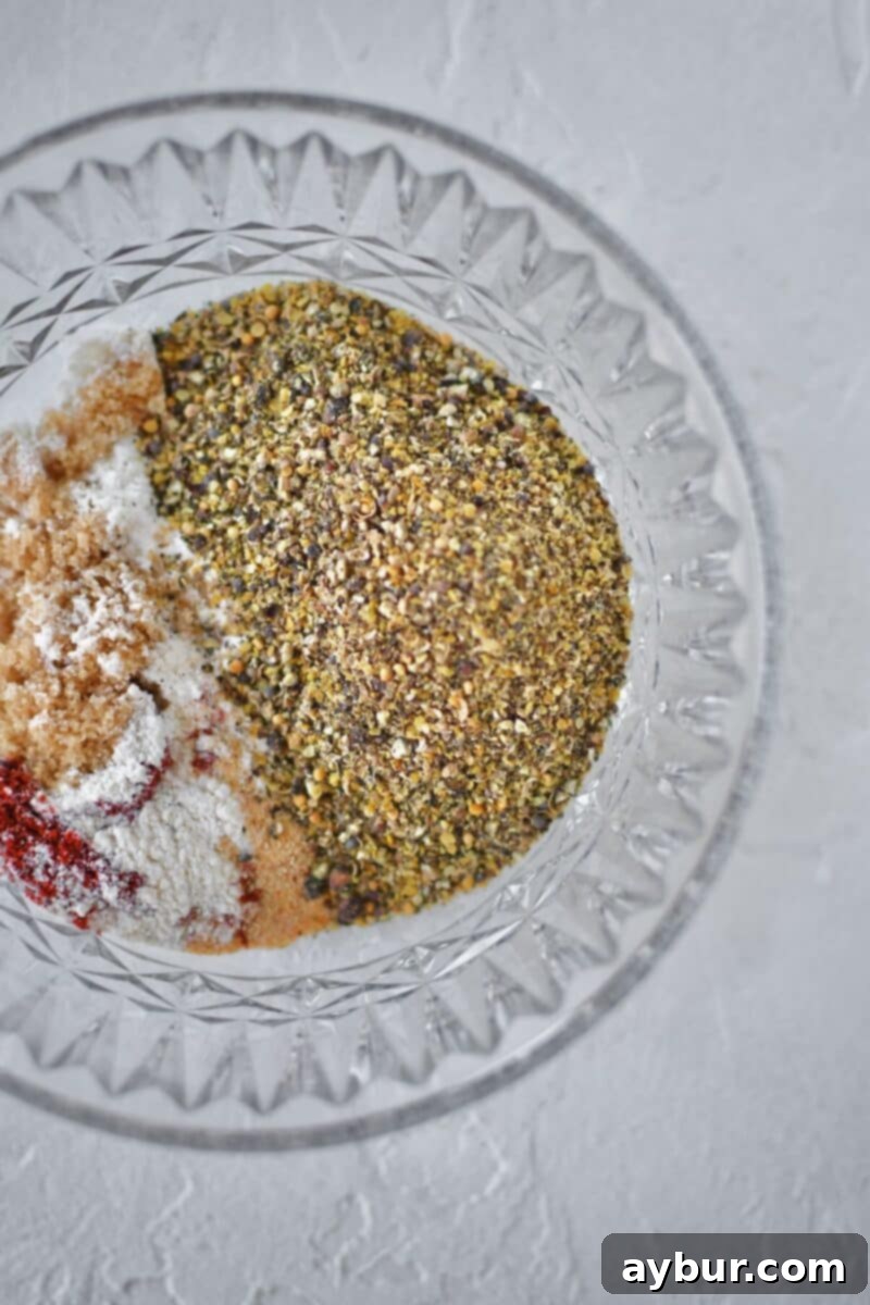 All the dry spice rub ingredients, including ground spices, sugar, and paprika, combined in a bowl for the homemade pastrami rub.