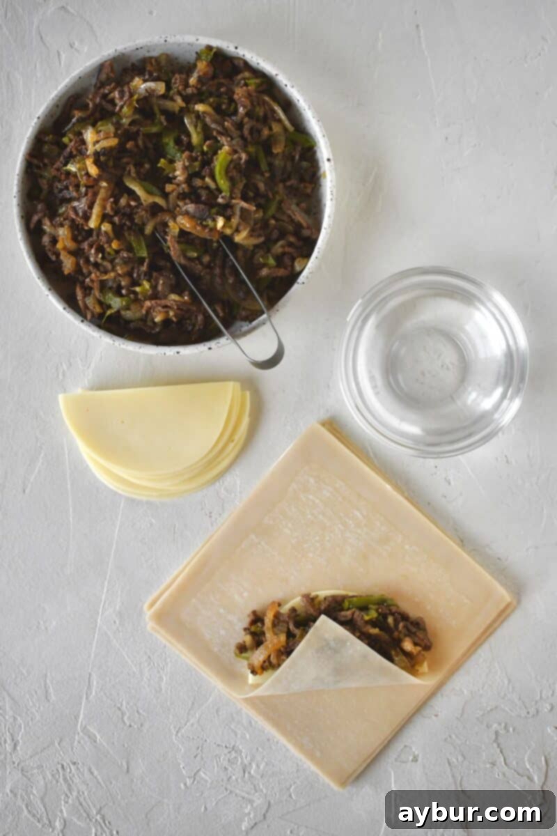 Beginning to fold an egg roll, folding up the bottom corner.