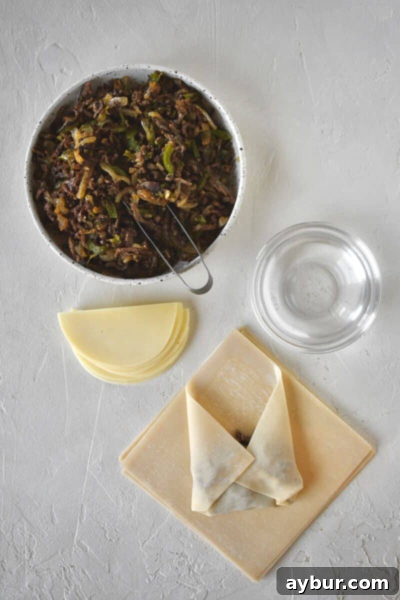 Beginning to fold an egg roll, folding up the bottom corner, and the sides before forming a cylinder.