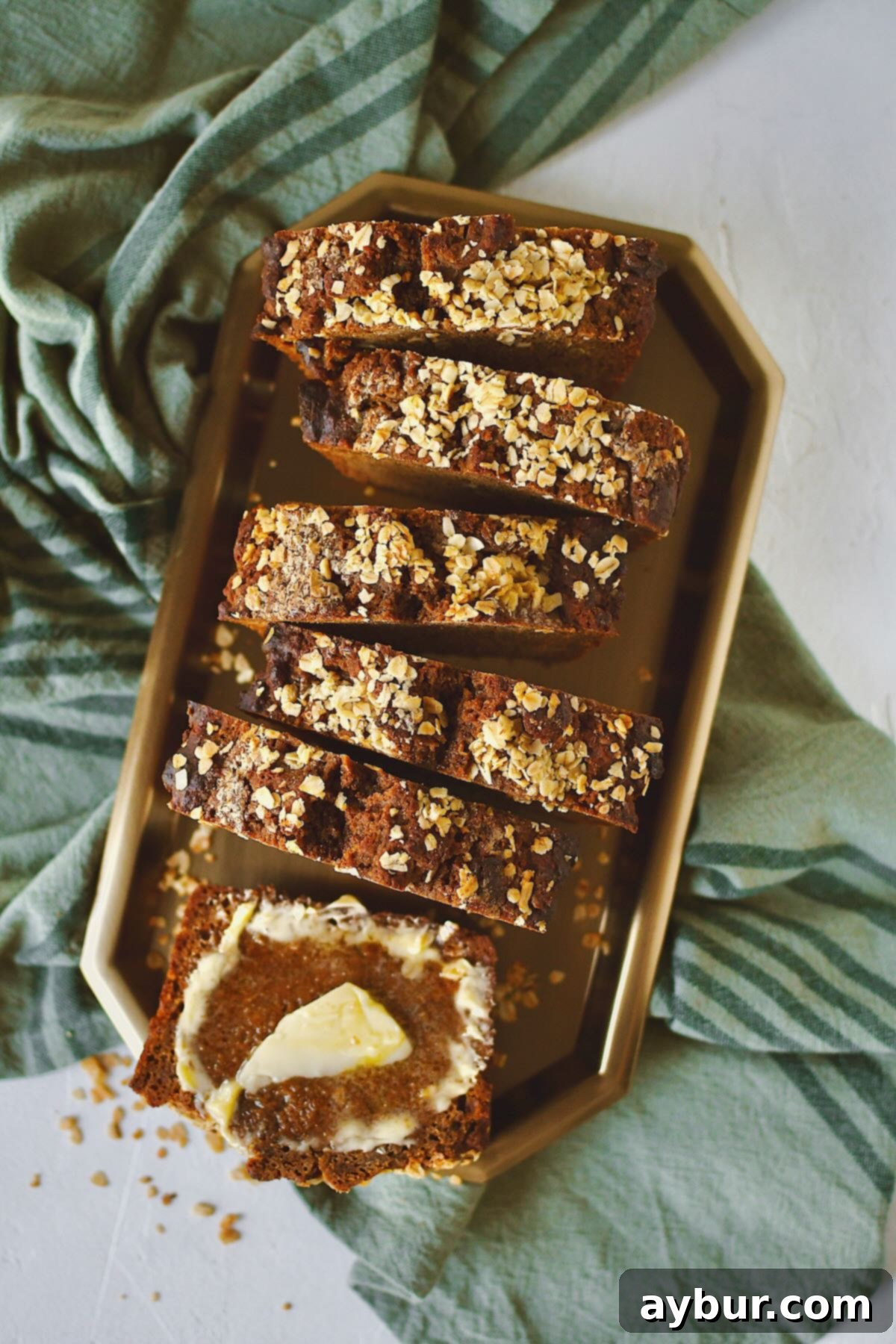 Traditional Irish Brown Bread 16 A close-up shot of a perfectly sliced loaf of Irish Brown Bread, with one slice buttered, presented on a wooden board.
