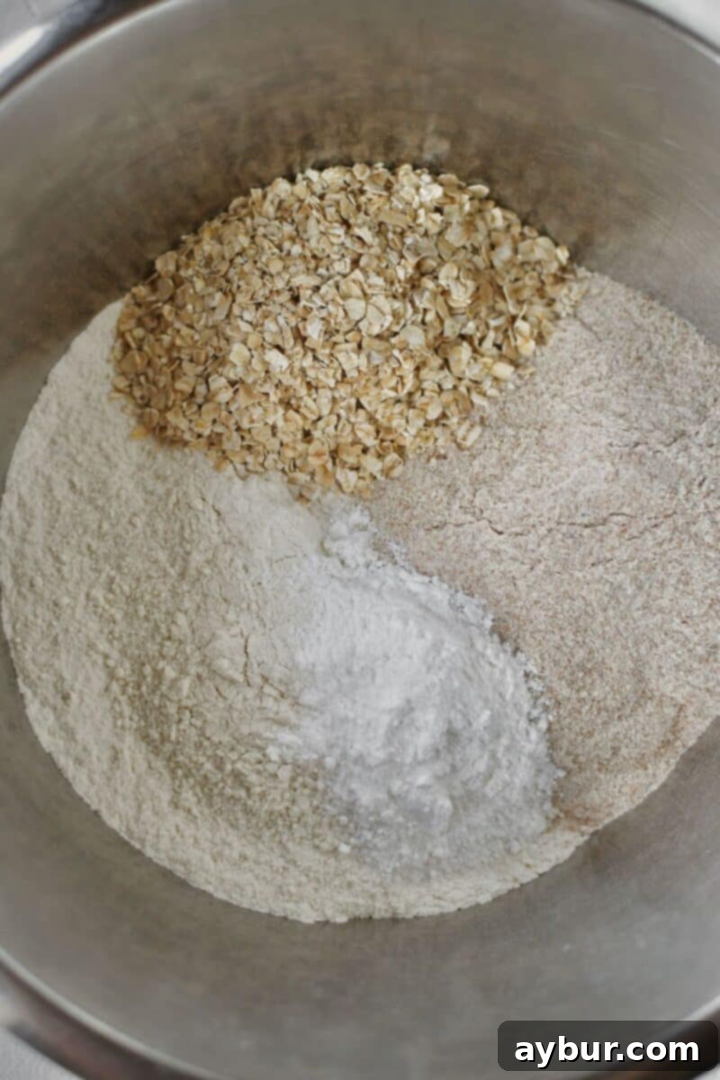 Traditional Irish Brown Bread 5 Dry ingredients like flour and oats are being added to a large mixing bowl.