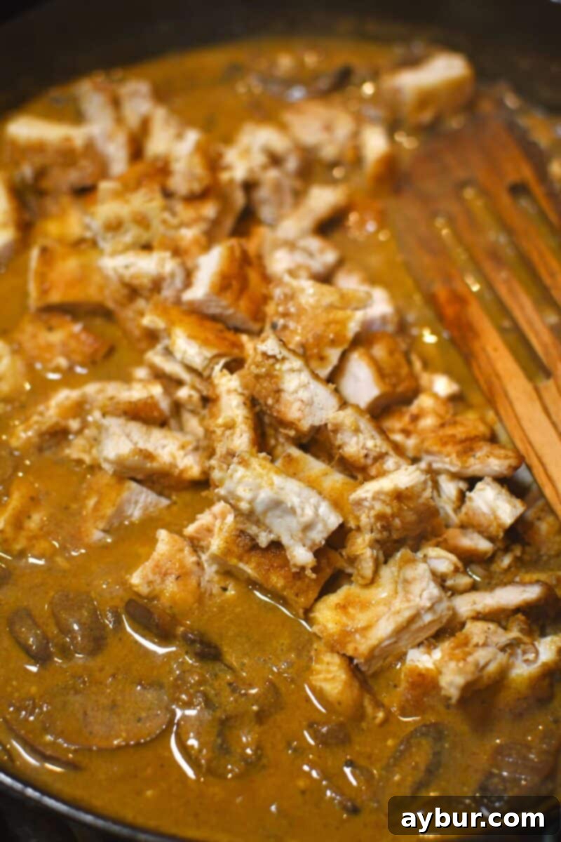 Creamy Chicken Stroganoff 12 Adding diced chicken back into the pan with the completed stroganoff sauce.