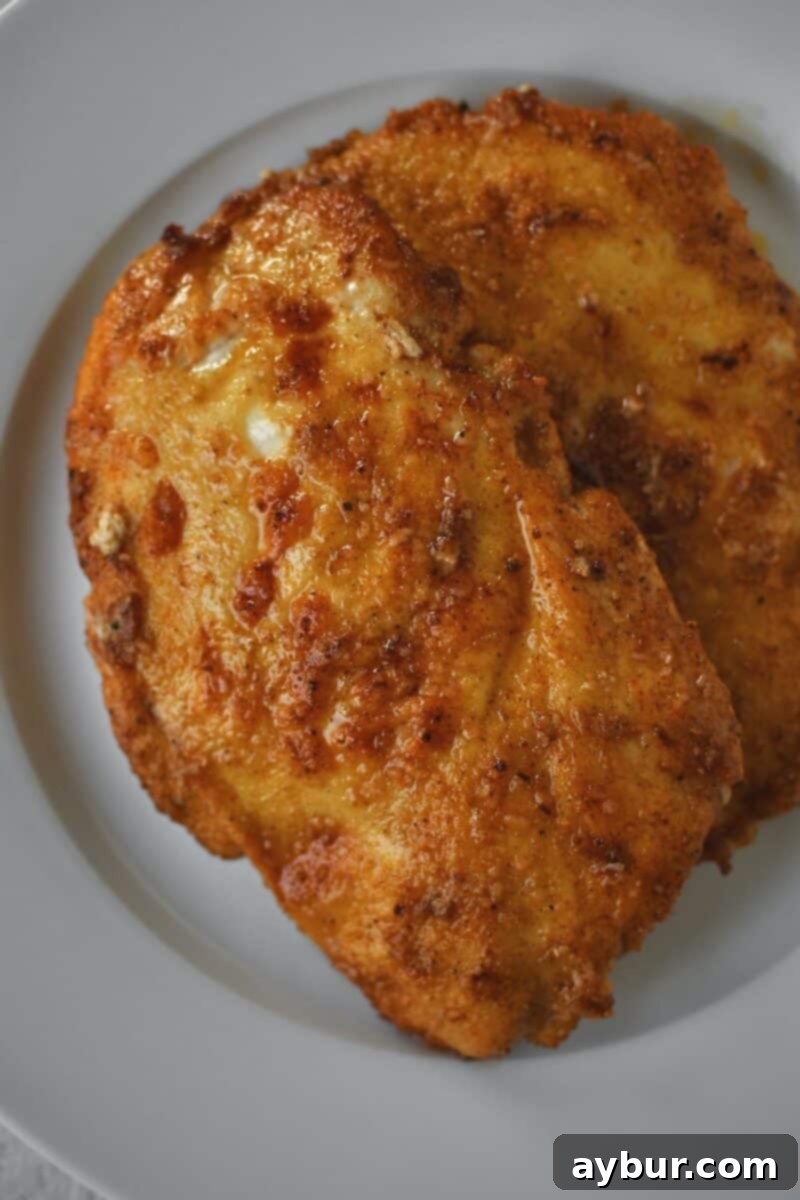 Creamy Chicken Stroganoff 5 Golden-brown seasoned chicken after searing, resting on a plate.