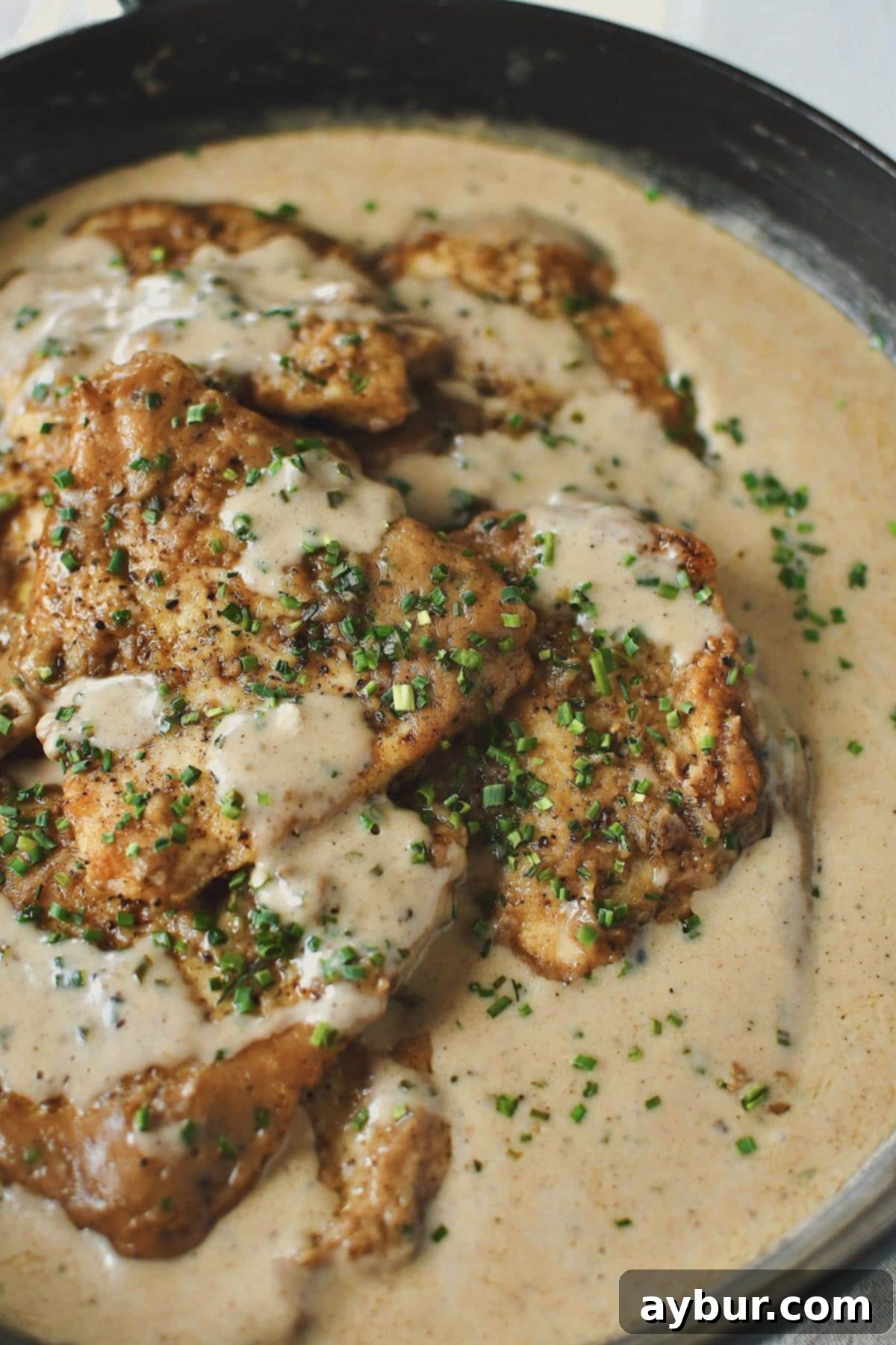 Creamy Irish Whiskey Chicken 2 Perfectly cooked Irish Chicken in Whiskey Cream Sauce, glistening and ready to serve, resting in a skillet.