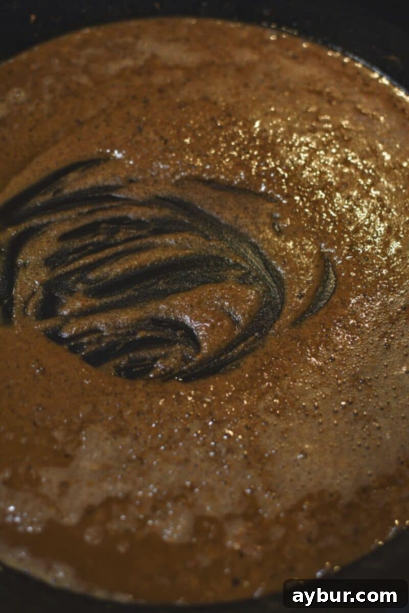 Creamy Irish Whiskey Chicken 7 Creating a roux by whisking butter and flour in the skillet, forming the base for the creamy whiskey sauce.