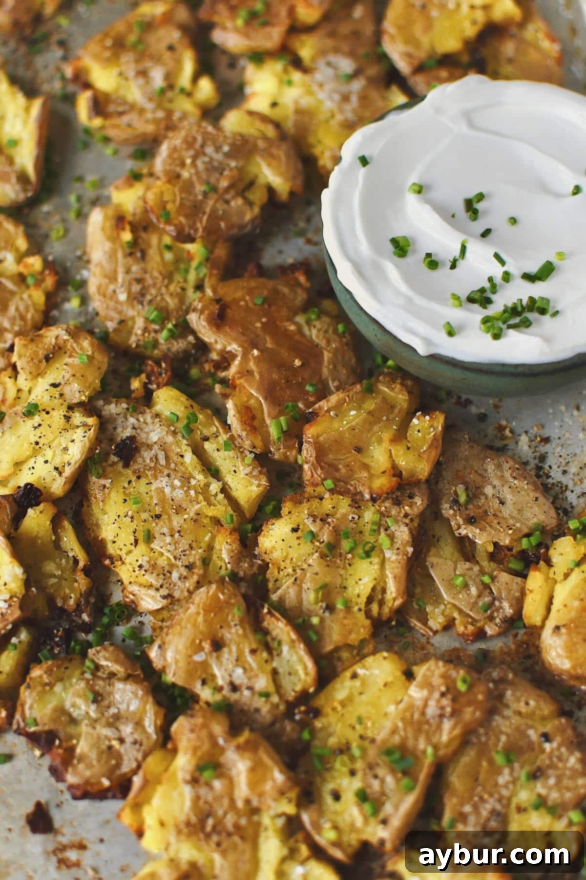 Crispy Smashed Potatoes just out of the oven ready to be enjoyed with some chive sour cream on the side.