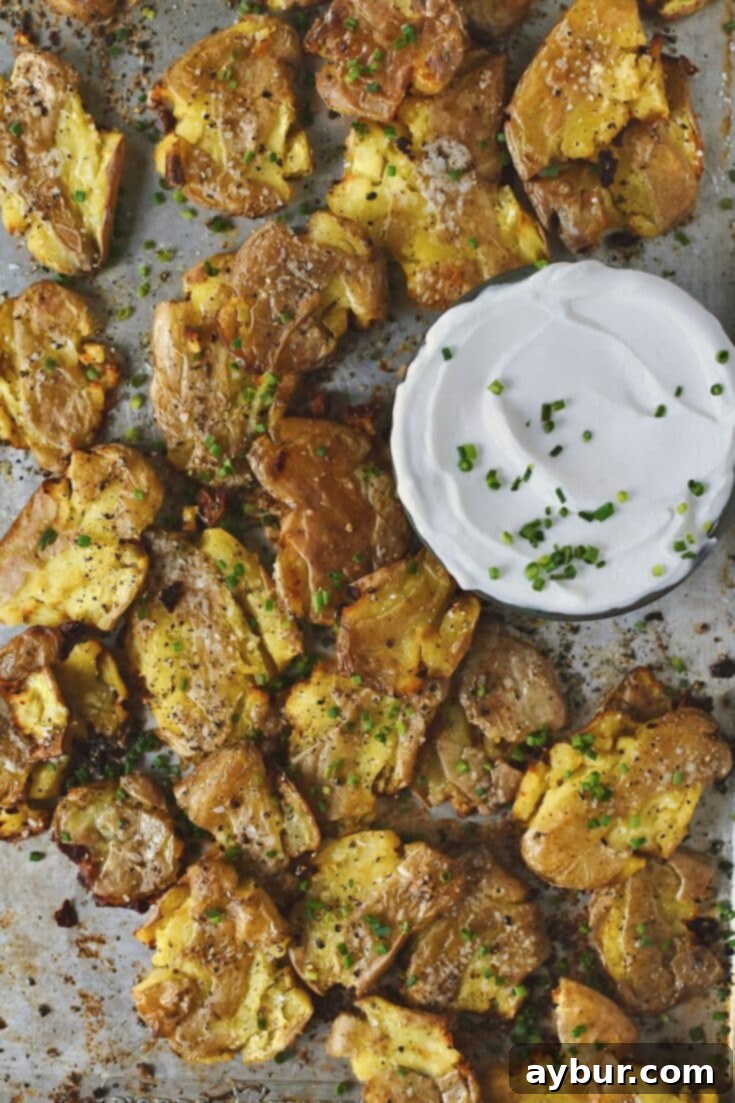 Crispy Smashed Potatoes just out of the oven ready to be enjoyed with some chive sour cream on the side.
