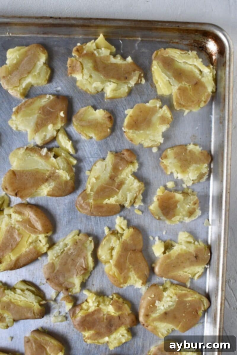 All potatoes smashed on a rimmed baking sheet.