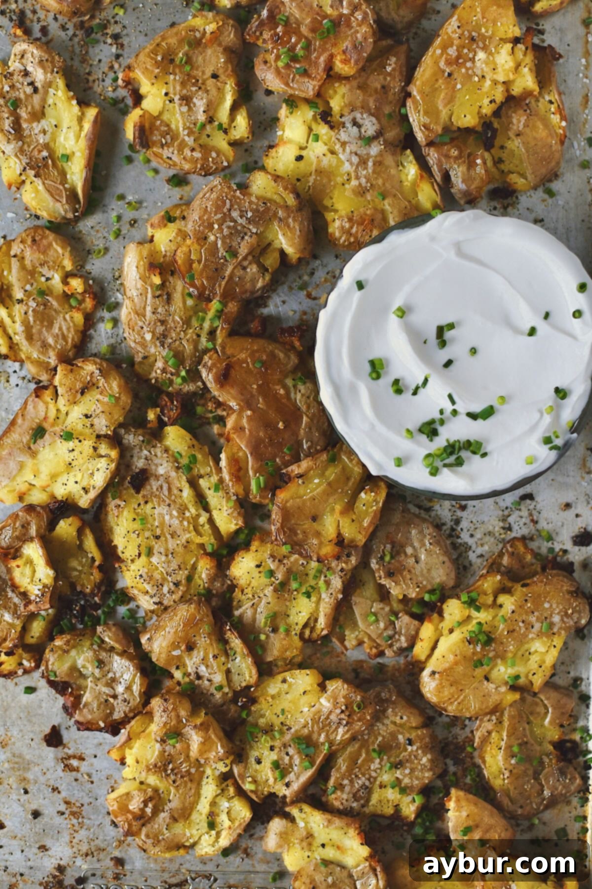 Crispy Smashed Potatoes just out of the oven ready to be enjoyed with some chive sour cream on the side.