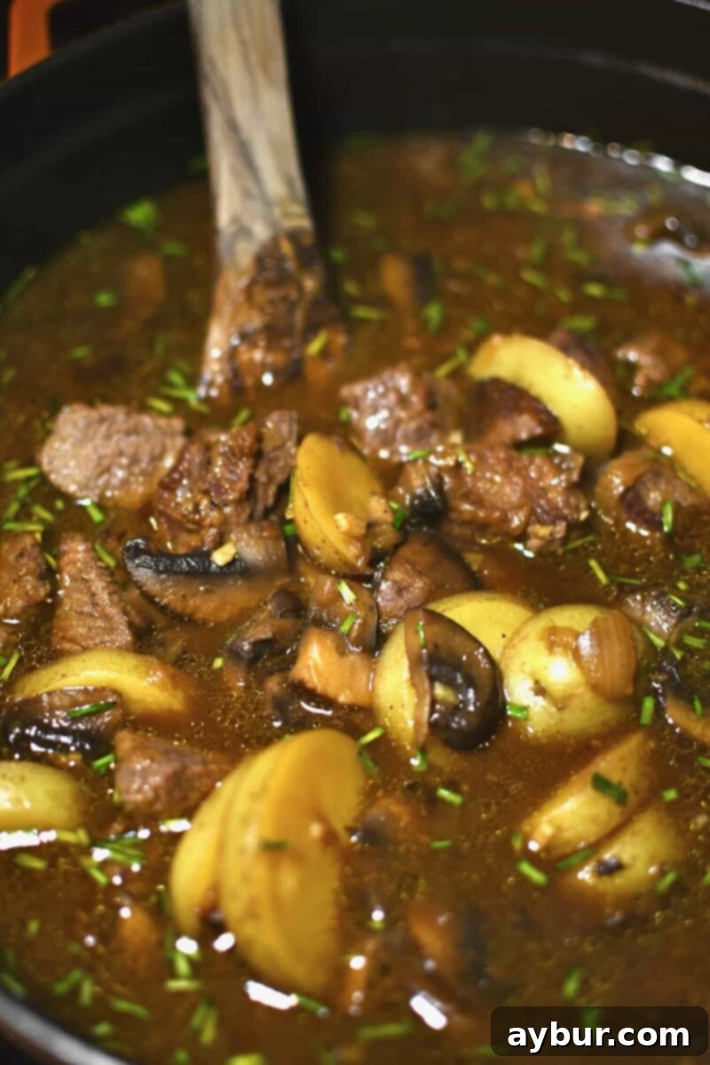Stirring the seared beef back into the soup just as the potatoes finish cooking, to warm it through without overcooking.