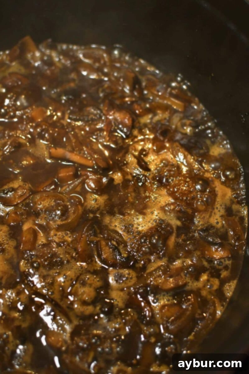 Deglazing the pan with amber ale beer, scraping up all the flavorful browned bits from the bottom of the pot.