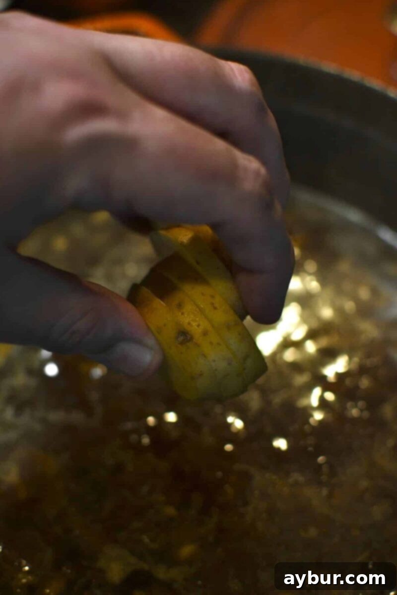 Gently placing sliced Yukon Gold potatoes into the simmering soup pot to cook until tender.