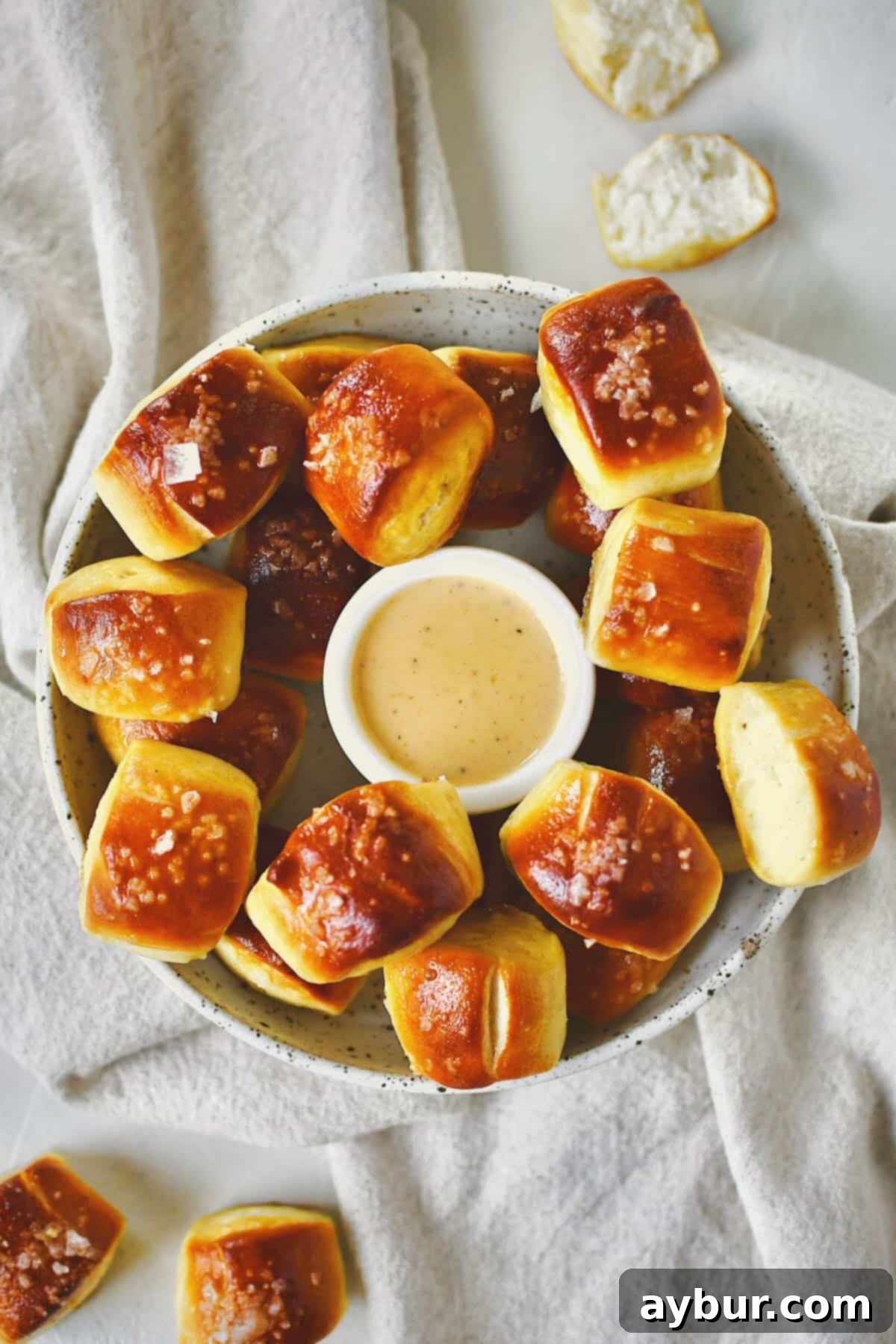 Homemade Pretzel Bites on a platter with cheese sauce in the middle for dipping.