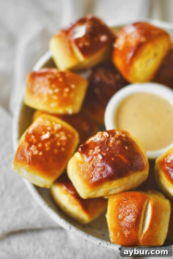 Homemade Pretzel Bites on a platter with cheese sauce in the middle for dipping.