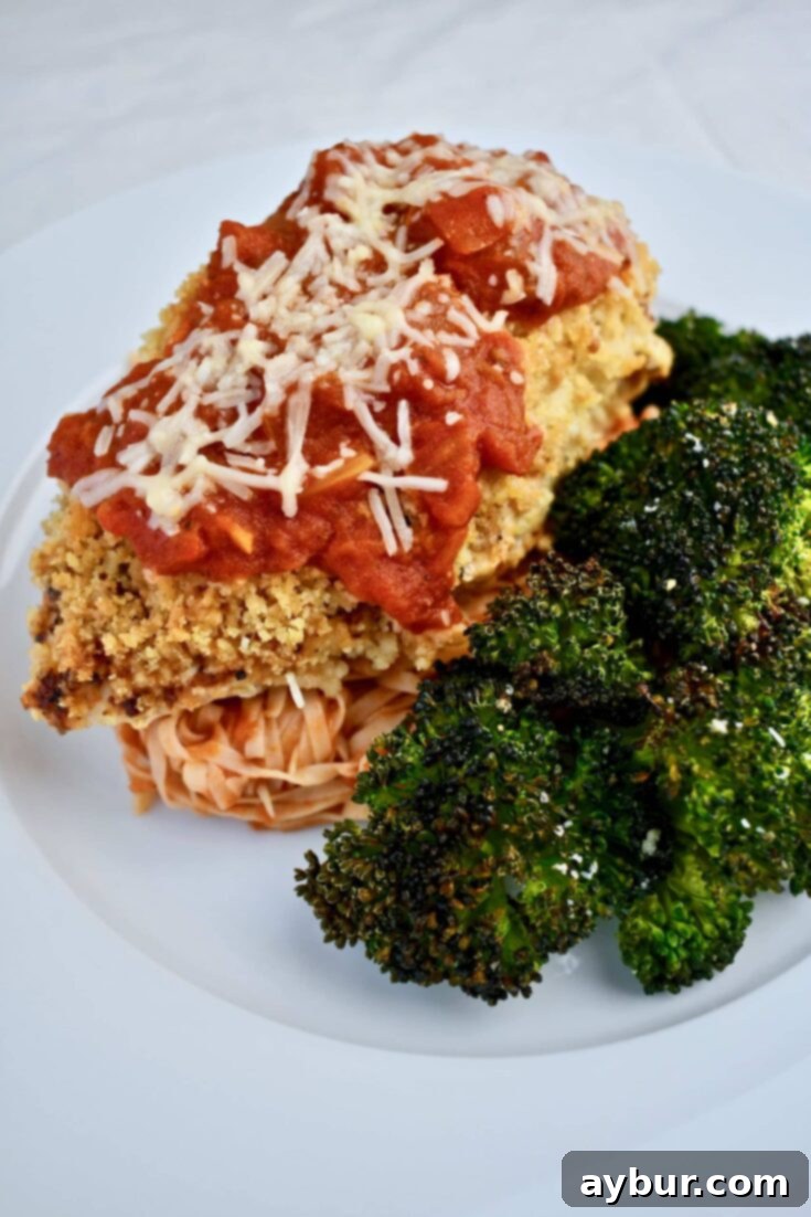 Crispy Chicken Parmesan 6 Chicken Parmesan, front view with a side of broccoli and pasta with sauce.