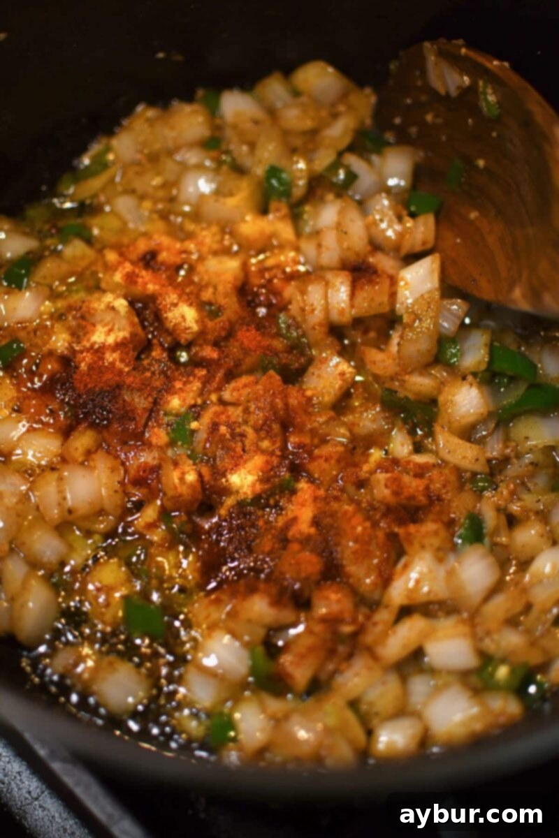 Adding the spices to the soup base, infusing rich aromas.