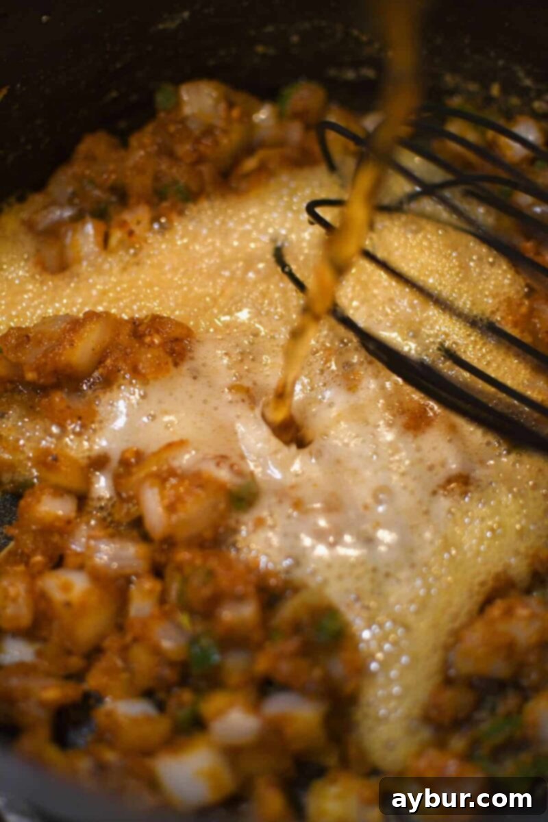 Deglazing the pan with a can of beer, adding depth of flavor.