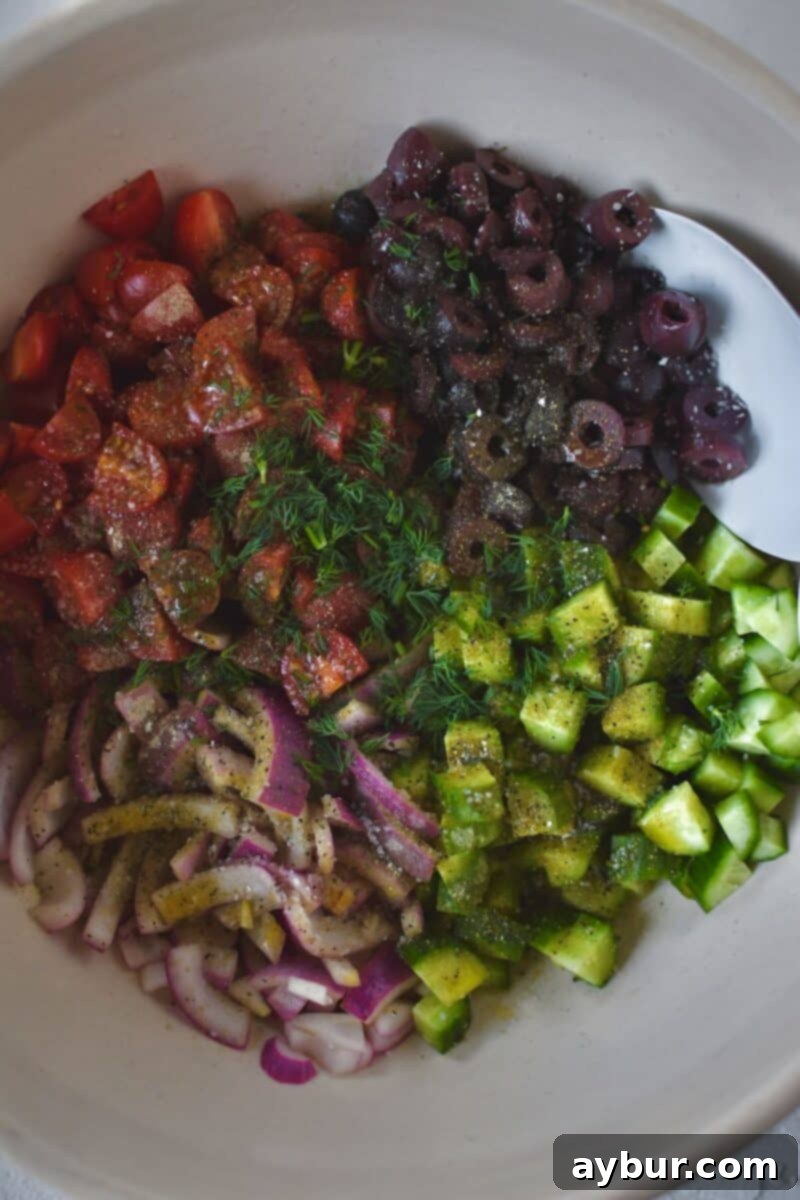 Zesty Greek Salmon 10 Adding the other veg to the bowl with the tomatoes and seasoning them.