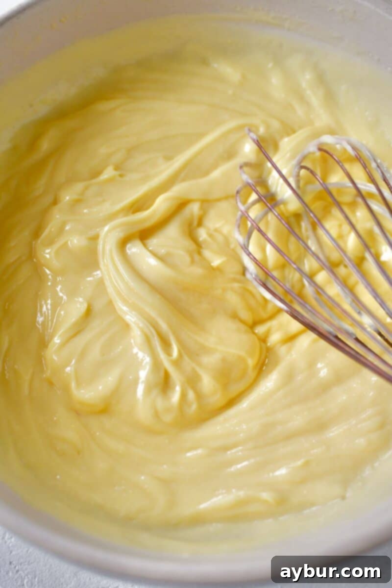 The milk and pudding mix after being thoroughly whisked for two minutes, showing a thick and smooth texture.