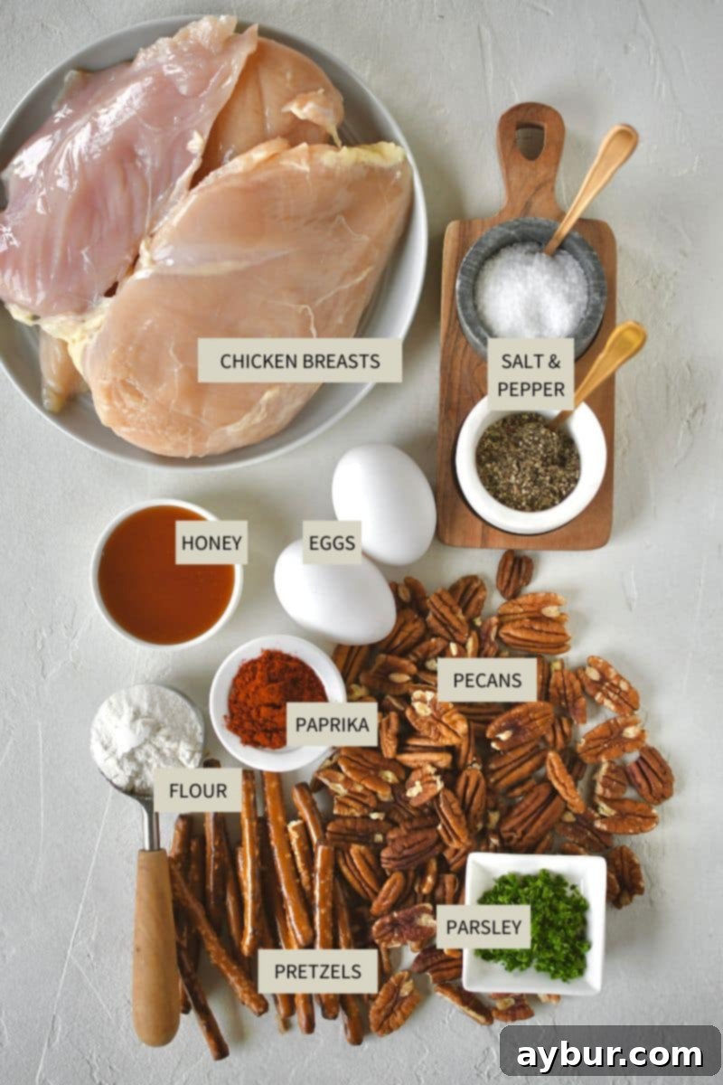 Crispy Pecan Chicken 3 A collection of ingredients laid out on a kitchen counter, including chicken breasts, pecans, pretzels, eggs, flour, and various spices, ready for making Pecan Crusted Chicken.