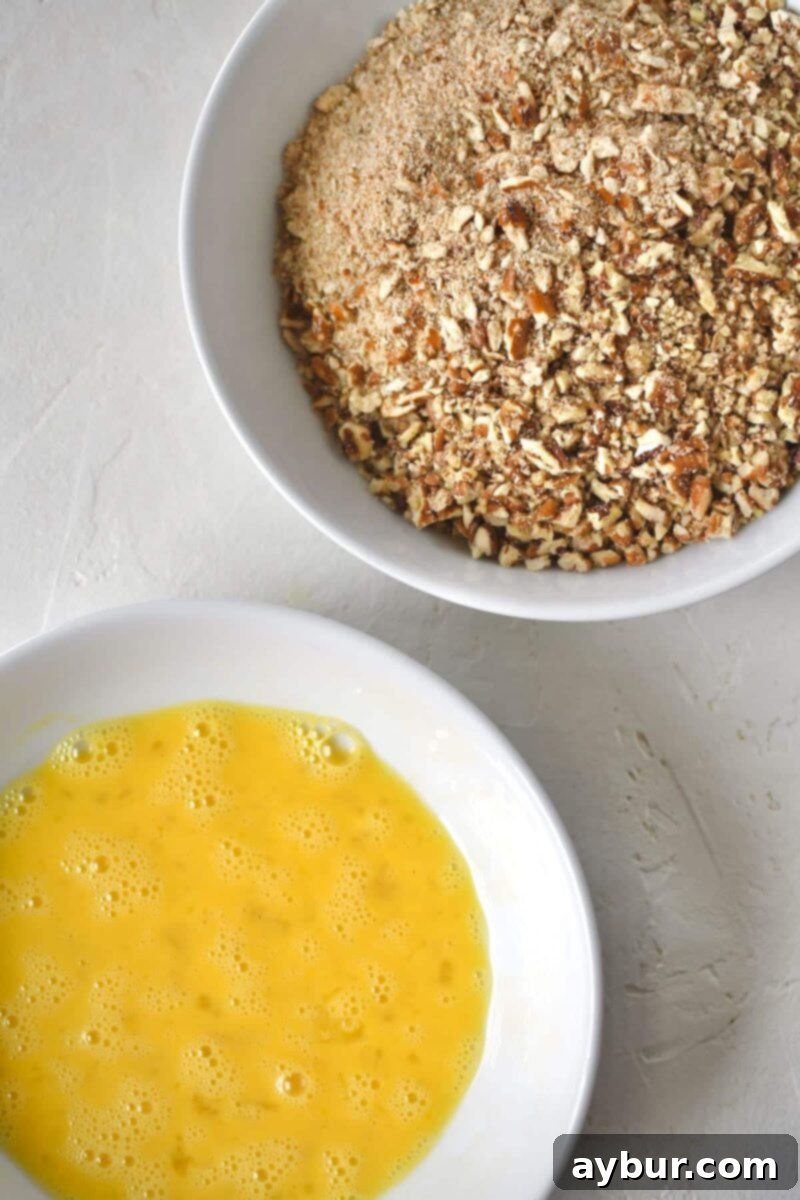 Crispy Pecan Chicken 5 Preparation steps for Pecan Crusted Chicken, showing whisked eggs in a bowl and a mix of crushed pecans and pretzels in another bowl, ready for coating.