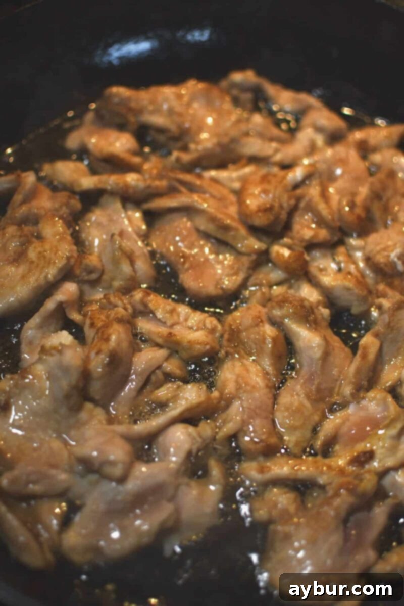 Cooking the quickly marinated chicken in the toasted sesame oil.