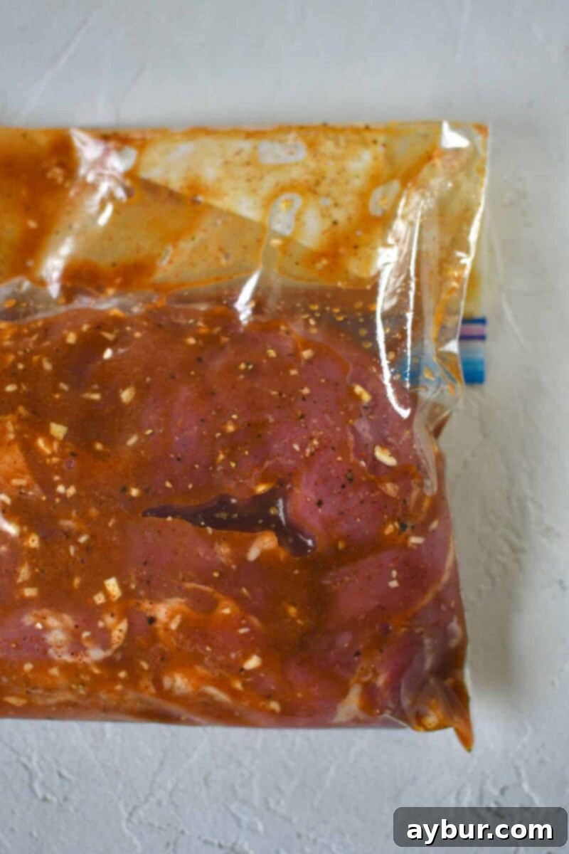 Pork tenderloins marinating in a zip top bag, absorbing all the delicious flavors.