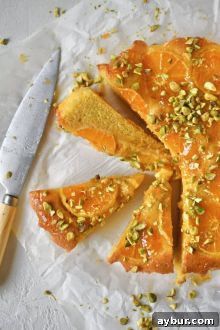 Tangerine Cake sliced and ready to be eaten, showcasing its beautiful layers and vibrant citrus appeal.