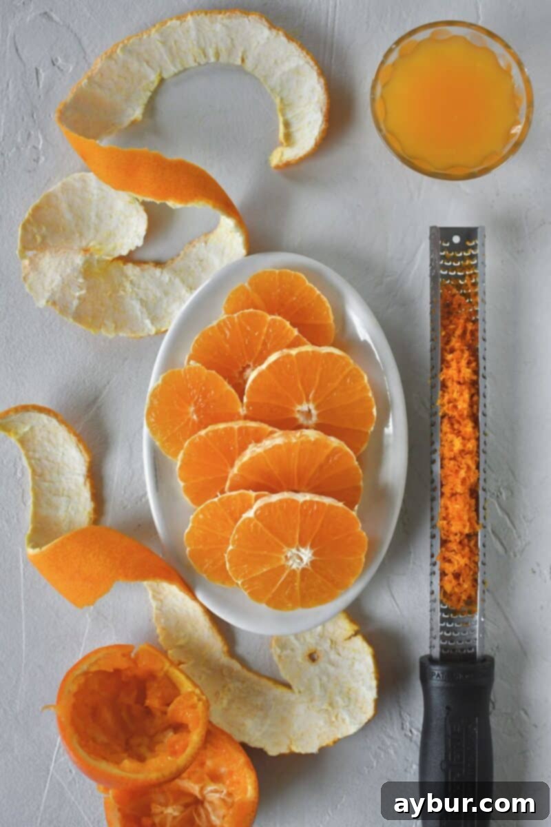Three tangerines meticulously prepared: two are zested, peeled, and thinly sliced, while the third has been freshly juiced for the cake batter.