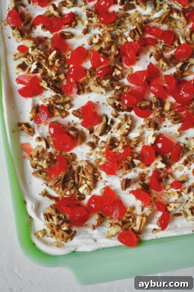 Ultimate Banana Split Cake 13 The fully chilled and delicious Banana Split Cake, garnished and ready to be served from the baking dish.