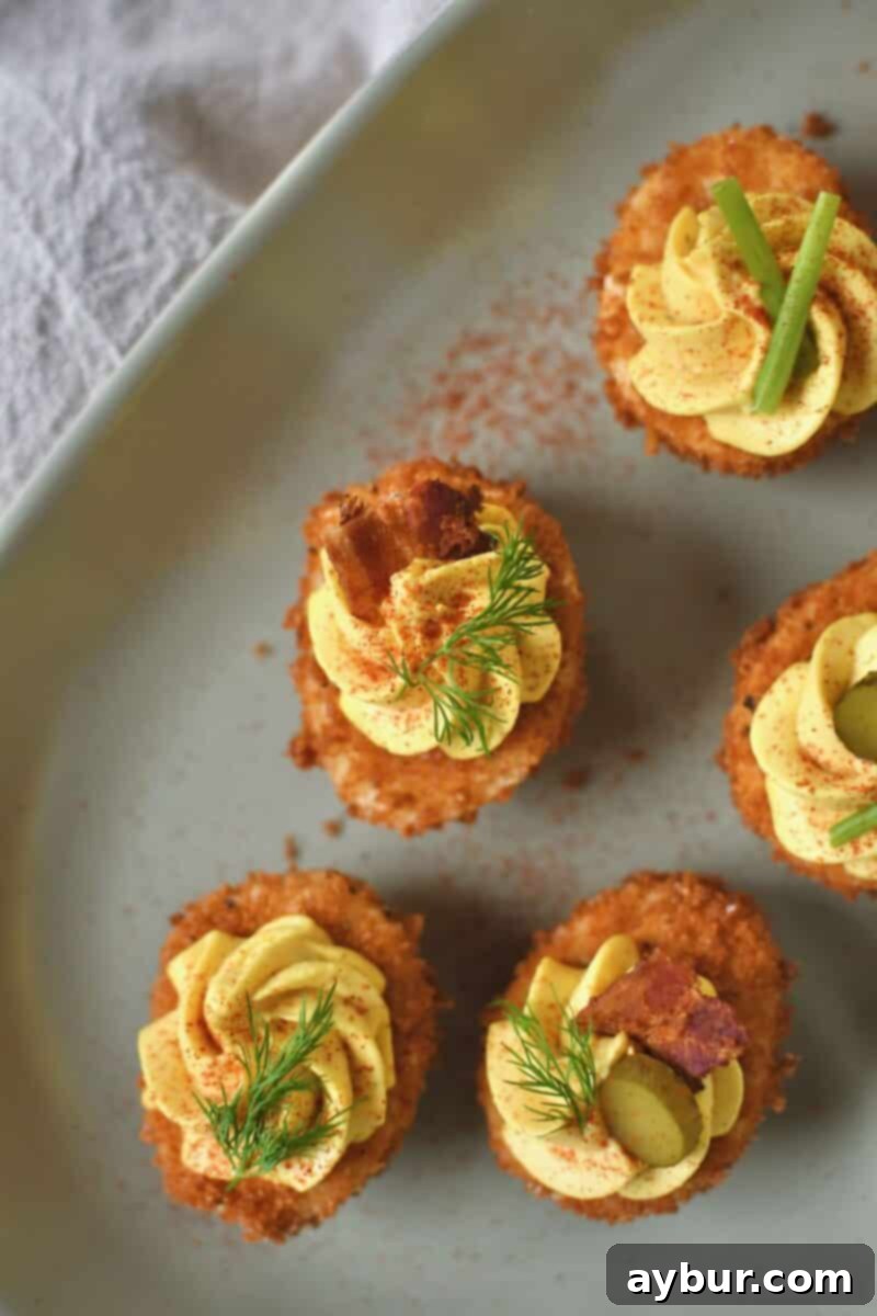 Crispy Deviled Eggs 9 Finished Deep Fried Deviled Eggs on a platter topped with an array of optional toppings like sliced gherkins, herbs, bacon, and shrimp.