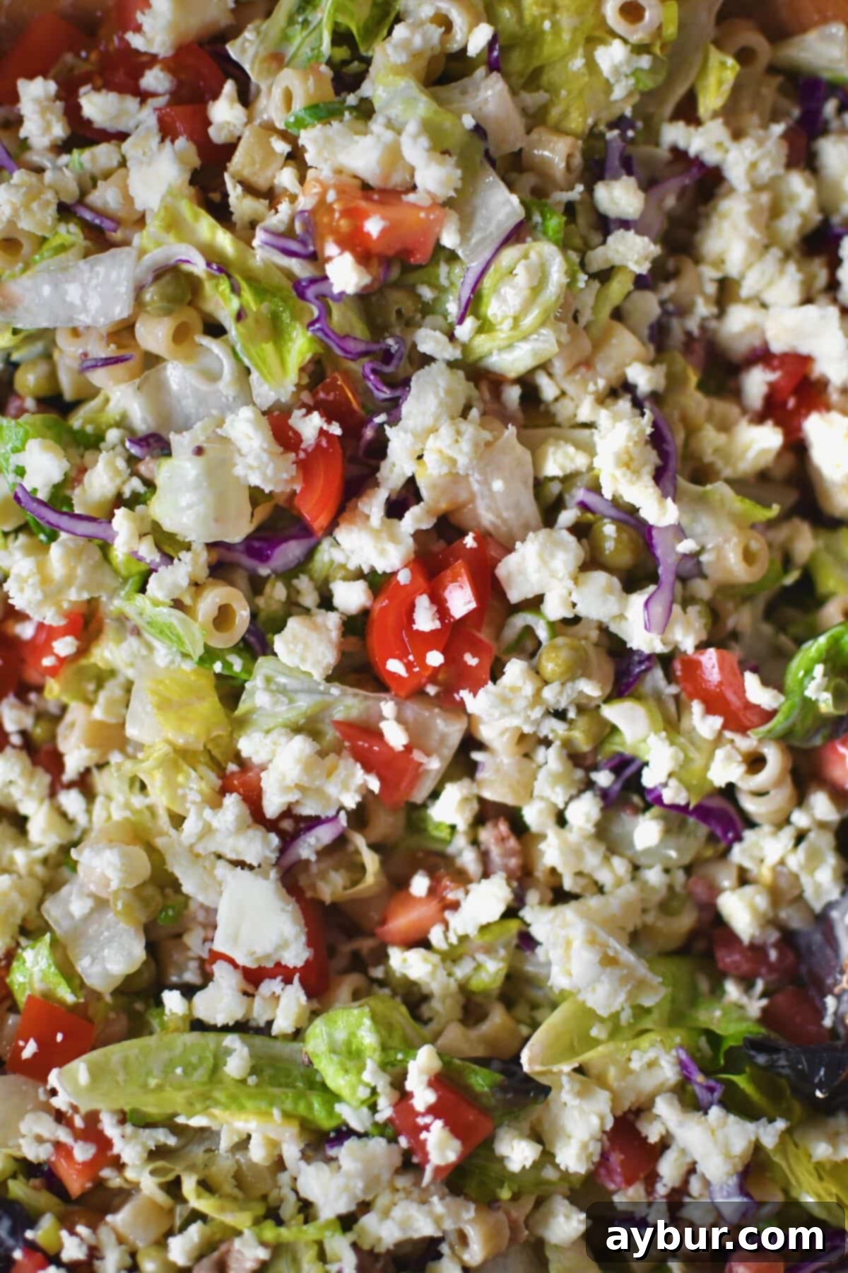 A close-up of the fully tossed Italian Pasta Salad, showcasing the vibrant ingredients and crumbled blue cheese.