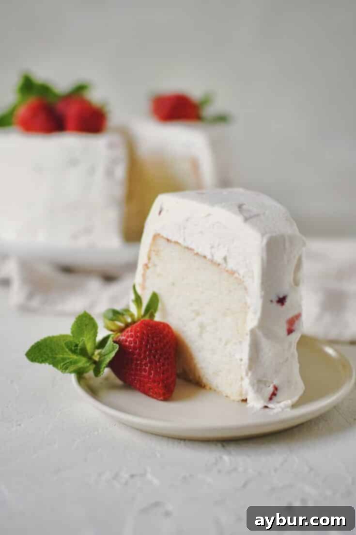 Strawberry Angel Food Cake with a single slice cut out of it.
