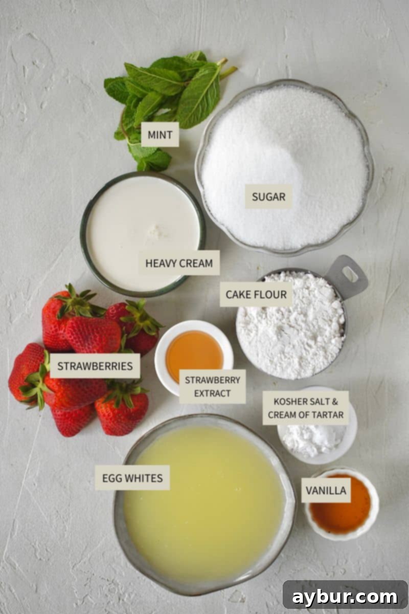 A collection of ingredients laid out, including cake flour, sugar, egg whites, vanilla extract, and fresh strawberries, ready for making Strawberry Angel Food Cake.