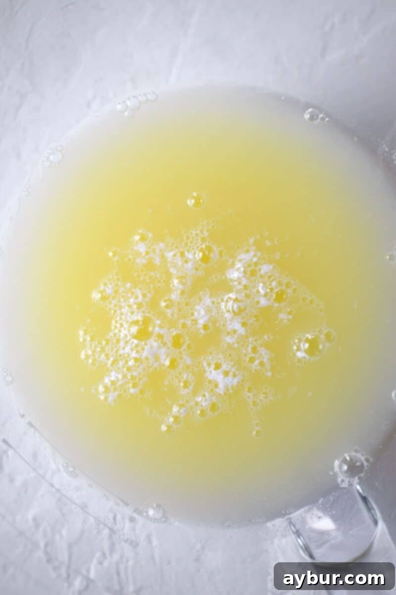 Fresh egg whites in a stand mixer bowl, ready for whipping.